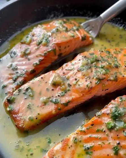 Plated Garlic Butter Salmon with herbs and lemon slices, ready to serve.