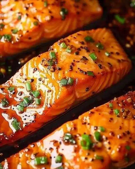 Honey butter salmon fillet garnished with herbs on a plate