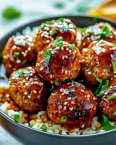 Honey Garlic Turkey Meatballs served in a bowl with a drizzle of sauce.