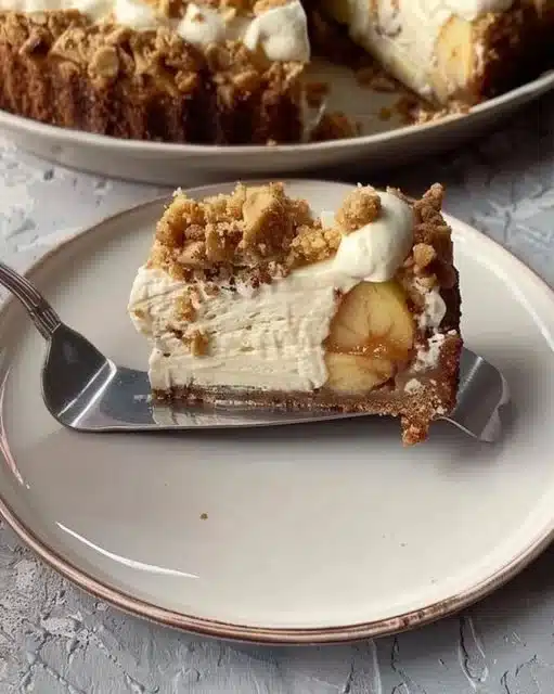 Slice of delicious Apple Crumble Cheesecake topped with crumble and apples