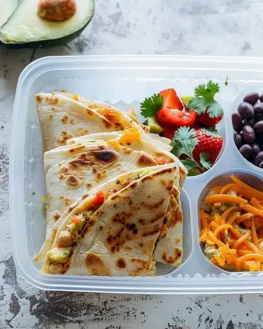 Avocado and hummus quesadillas served on a plate with fresh ingredients.
