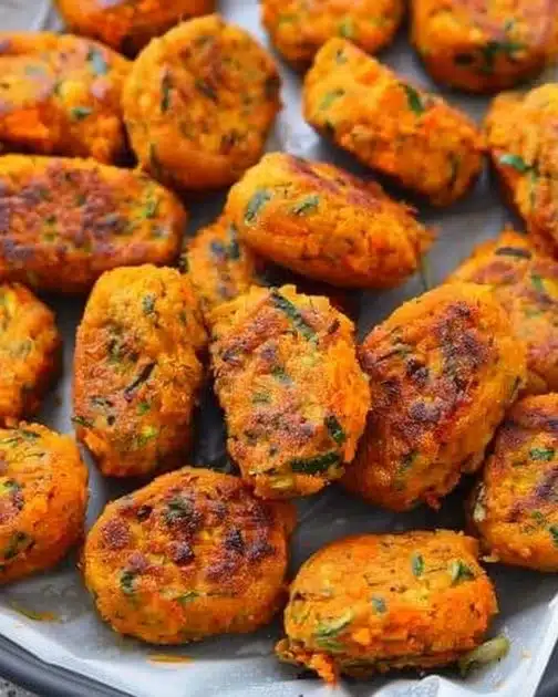 Baked sweet potato zucchini tots on a plate, healthy snack idea.
