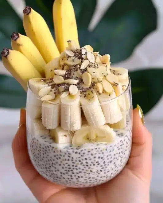 Delicious bowl of banana chia pudding topped with sliced bananas and nuts
