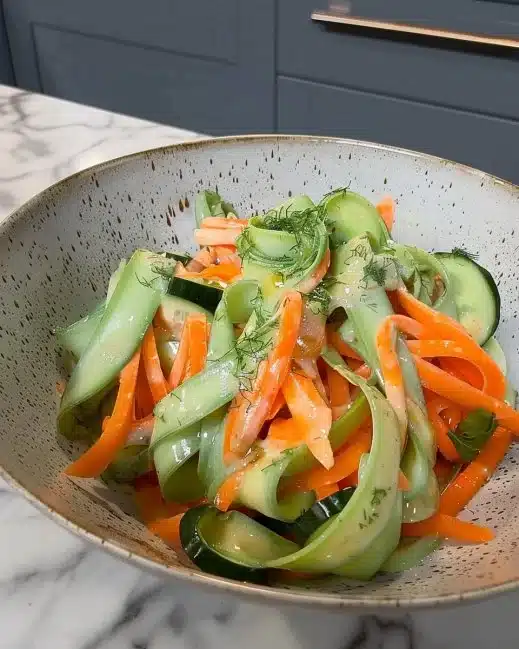 Carrot & Cucumber Ribbon Salad garnished with fresh herbs