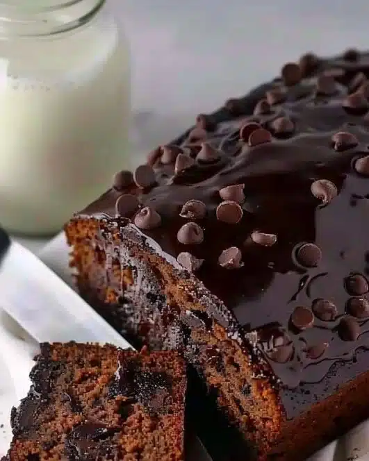 Delicious slice of Chocolate Banana Bread with chocolate chips on a wooden table