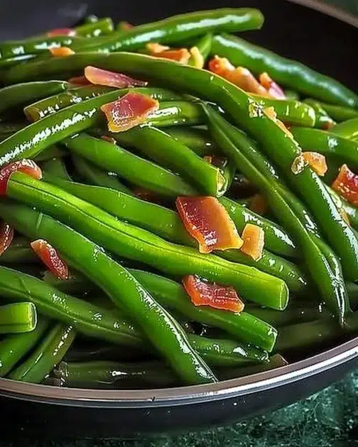 Plate of crack green beans with crispy bacon, showcasing a tasty side dish