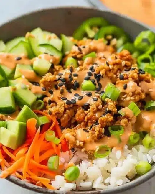 Delicious ground turkey rice bowl topped with Bang Bang sauce and fresh veggies.