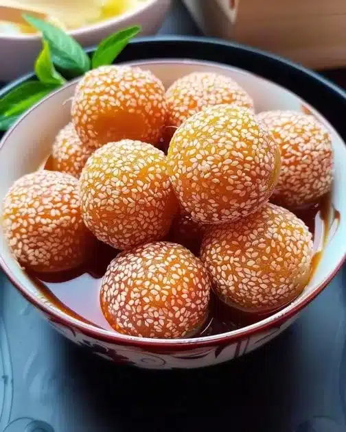 Crispy sweet potato balls served on a plate, garnished and ready to eat.