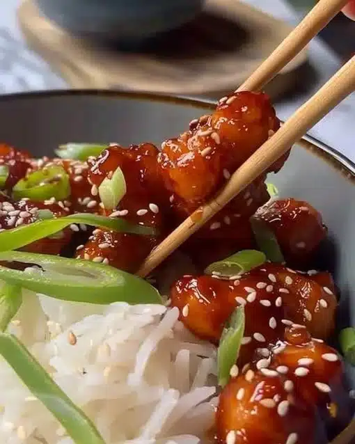 Delicious Air Fryer Sesame Chicken served with sesame seeds and vegetables.