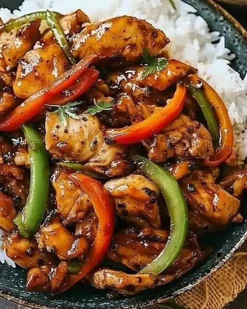 Plate of Black Pepper Chicken garnished with fresh herbs