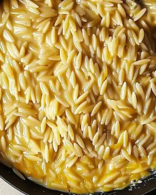 Bowl of creamy cottage cheese orzo topped with herbs and spices