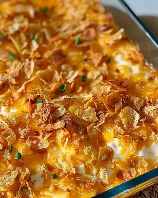 A dish of creamy Funeral Potatoes topped with golden breadcrumbs, served warm.