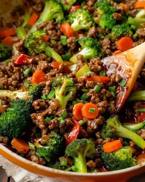 Plate of ground beef and broccoli stir-fry with rice and soy sauce