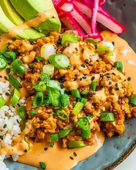 Ground turkey rice bowl with colorful vegetables and bang bang sauce