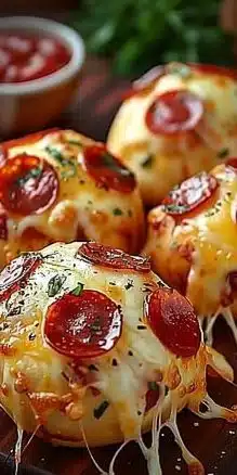 Delicious pepperoni pizza bombs served on a platter with dipping sauce.