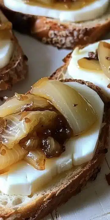 Brie Crostini topped with caramelized onions, served on a rustic platter