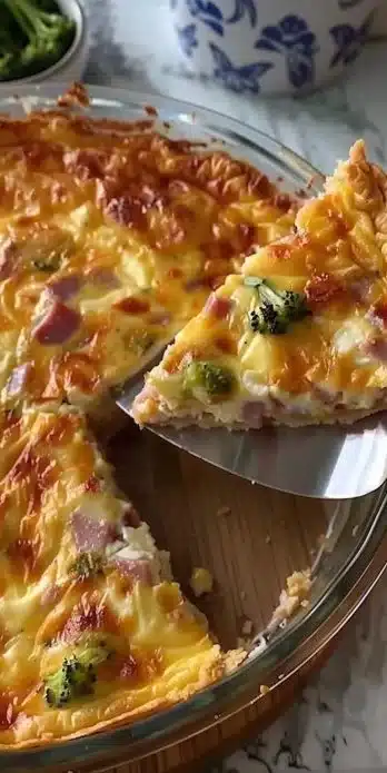 Crustless ham and cheese quiche served on a plate with fresh herbs
