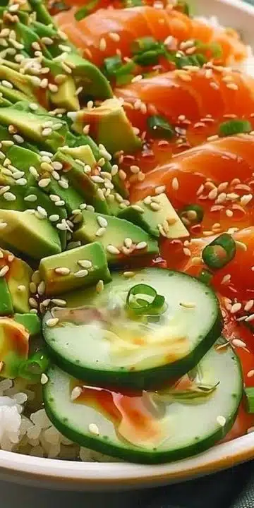 Salmon bowls with avocado and cucumber served in a vibrant dish.