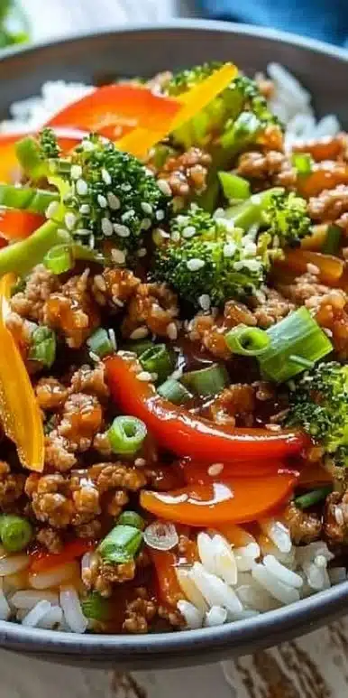 Delicious Bang Bang Ground Turkey Rice Bowl topped with fresh vegetables and sauces