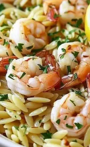 Delicious shrimp orzo cooked in lemon garlic sauce, served on a plate.